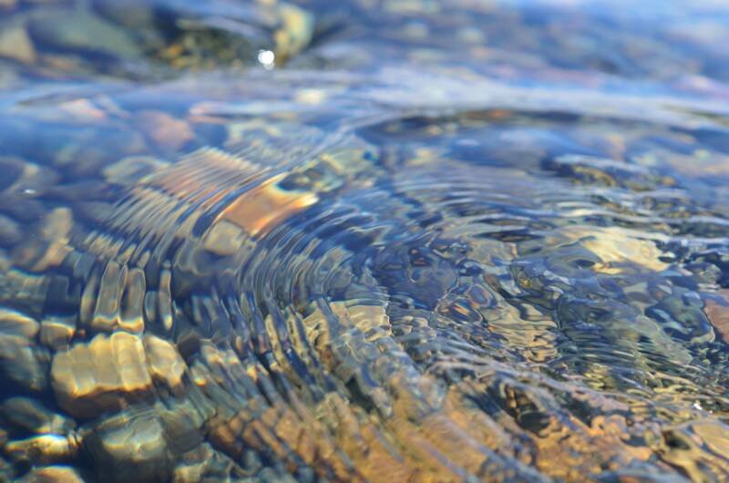 Hermosas ondas en el flujo del río sobre piedras de colores